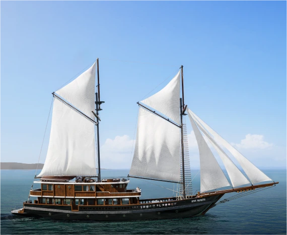 Luxury wooden yacht with white sails on blue water
